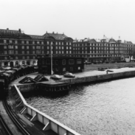 10. Islands Brygge, 1984. Til venstre ser man et tog ved den jernbanesvingbro, der blev bygget syd for Langebro i 1954. Der er den dag i dag flere spor af jernbanen. Bl.a. findes de gamle brofagsfundamenter i havnen, mens dele af de gamle jernbanespor også kan ses langs Havneparken på Islands Brygge.